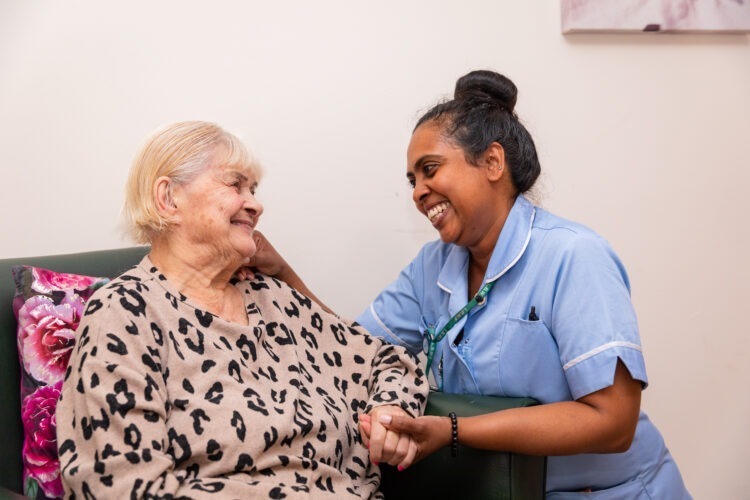 resident sitting and smiling with carer
