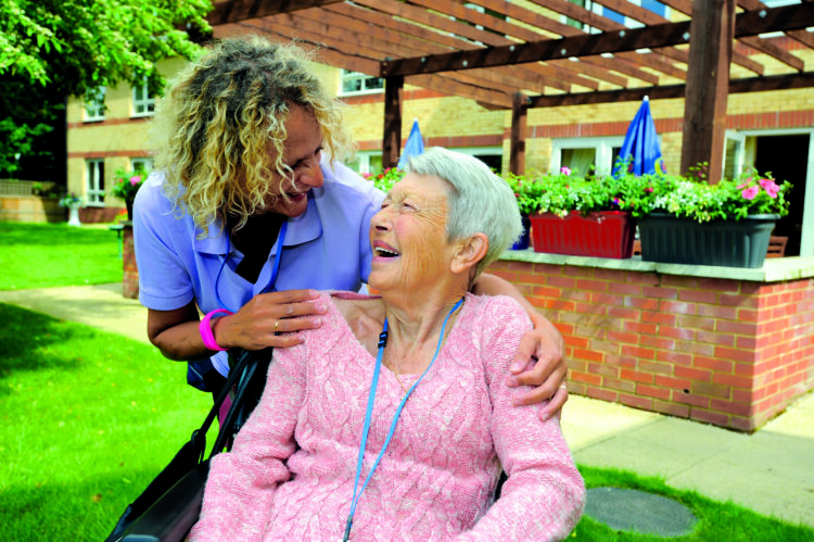 resident sitting down laughing with carer