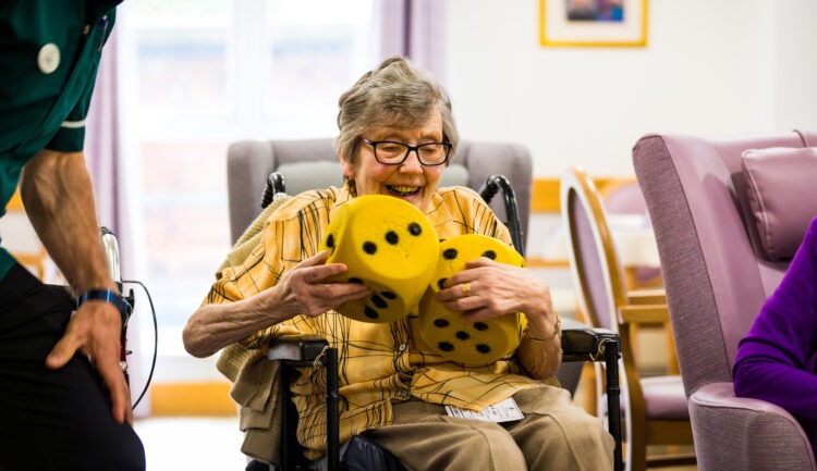 resident playing with large dice